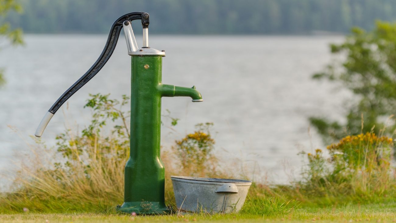 Water,Pump,In,Front,Of,A,Lake,In,Summertime